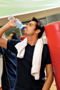 health club: athlete relaxing and drinking some water