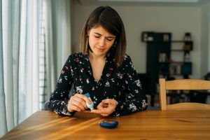 Young woman measuring blood sugar level